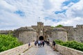 Ambrose Gate and bridge leading to it in Rhodes old town with tourists